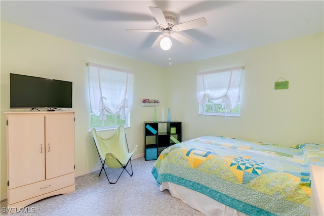 carpeted bedroom featuring multiple windows and ceiling fan