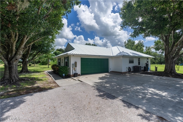 single story home featuring central AC, a garage, and a front lawn