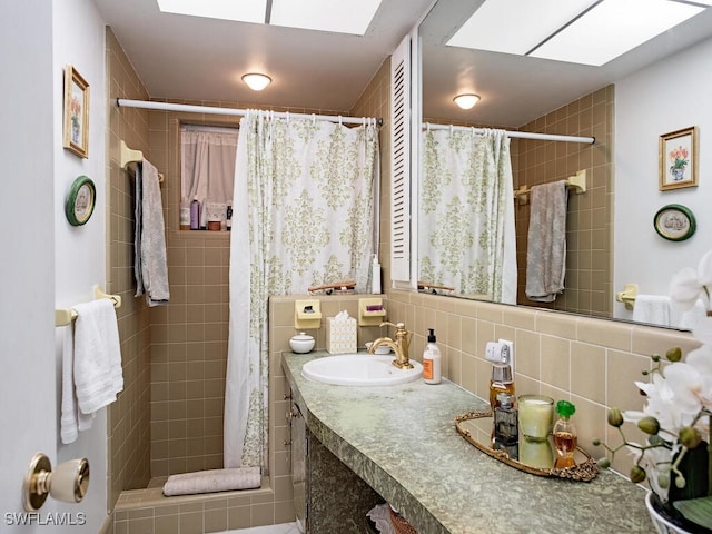 bathroom featuring tile walls, tasteful backsplash, a skylight, and vanity