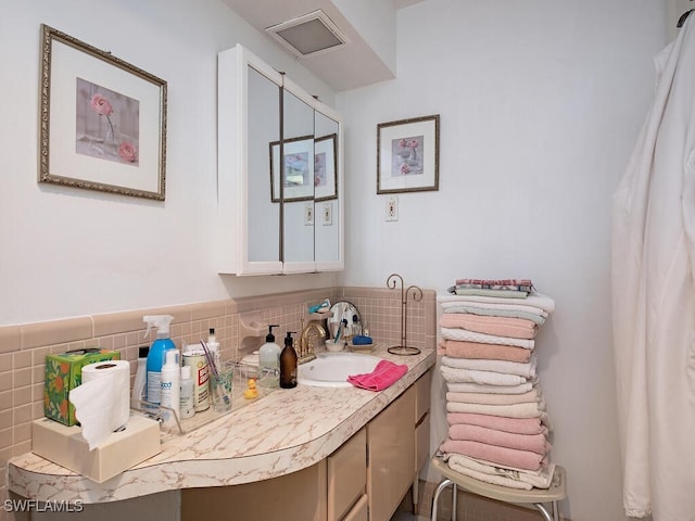 bathroom with decorative backsplash and vanity