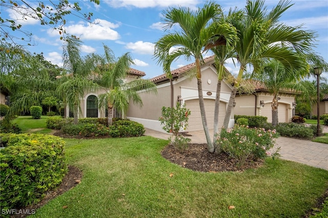 mediterranean / spanish-style house with a garage and a front lawn