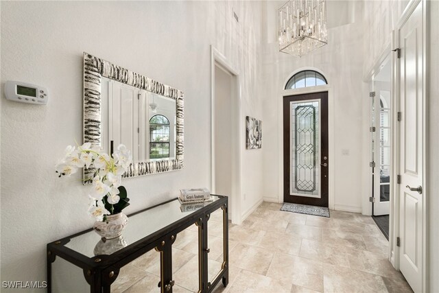 foyer with a notable chandelier and a towering ceiling