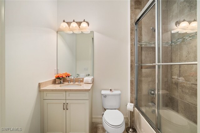 full bathroom featuring enclosed tub / shower combo, vanity, and toilet