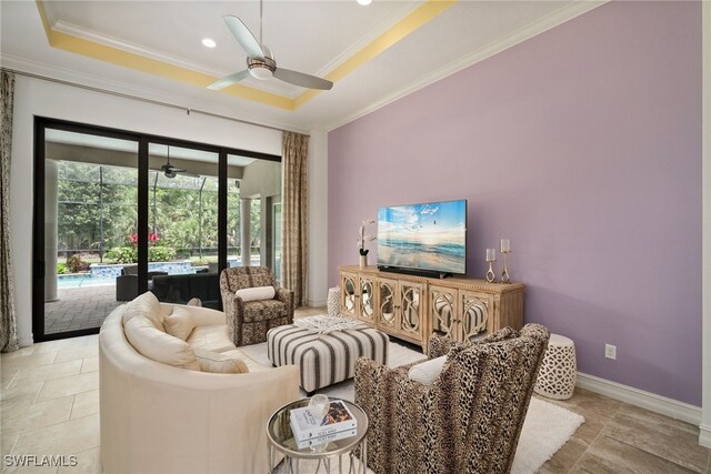 living room featuring light tile patterned floors, crown molding, a raised ceiling, and ceiling fan