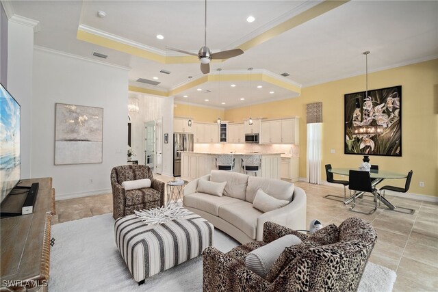 living room featuring ornamental molding, ceiling fan, and a raised ceiling