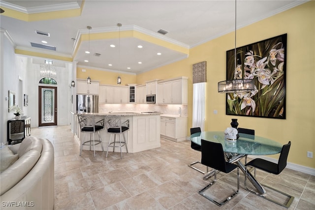 kitchen with a kitchen island, pendant lighting, appliances with stainless steel finishes, and white cabinets