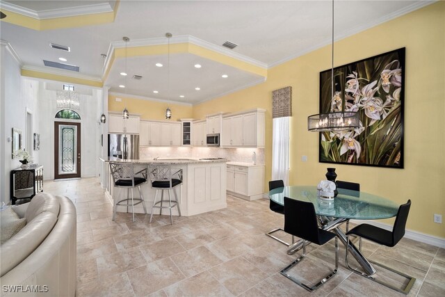 kitchen featuring stainless steel appliances, white cabinetry, a kitchen island, and pendant lighting