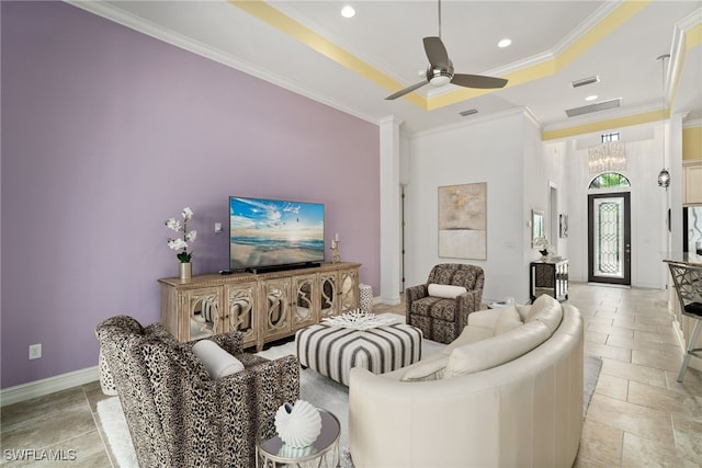 living room featuring ceiling fan with notable chandelier, a raised ceiling, and crown molding