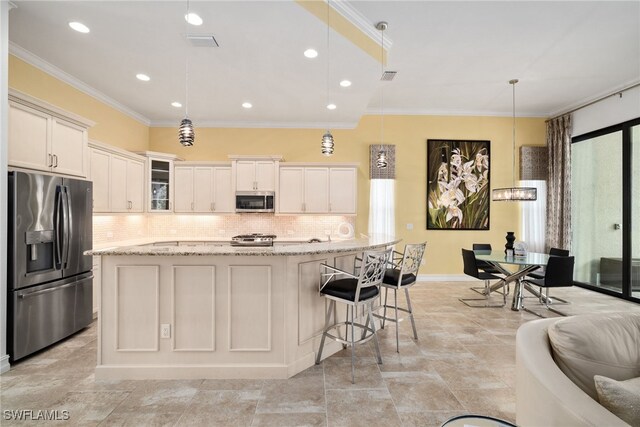 kitchen featuring pendant lighting, appliances with stainless steel finishes, white cabinetry, light stone countertops, and a center island with sink