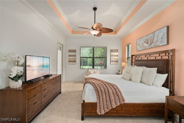 carpeted bedroom featuring crown molding, ceiling fan, and a raised ceiling