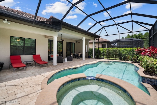 view of pool featuring glass enclosure, a patio, ceiling fan, and an in ground hot tub