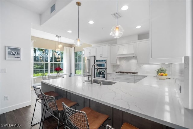 kitchen featuring premium range hood, pendant lighting, and a kitchen breakfast bar