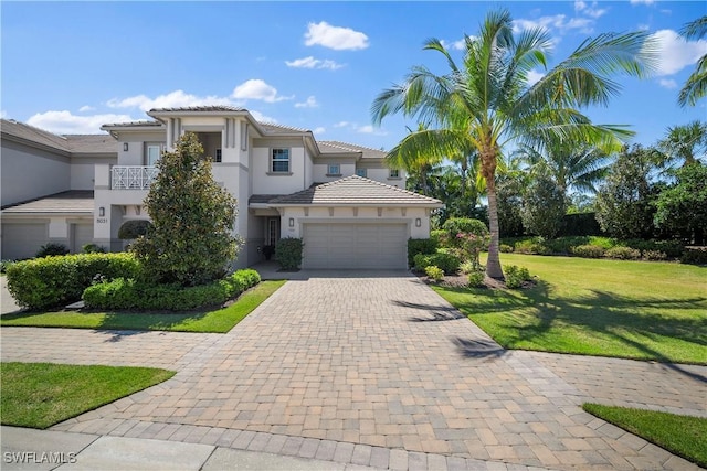 mediterranean / spanish-style house featuring a front yard, a balcony, and a garage