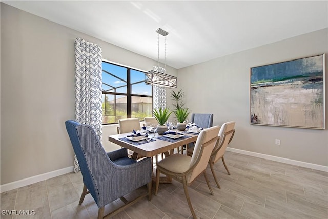 dining room featuring a chandelier and baseboards