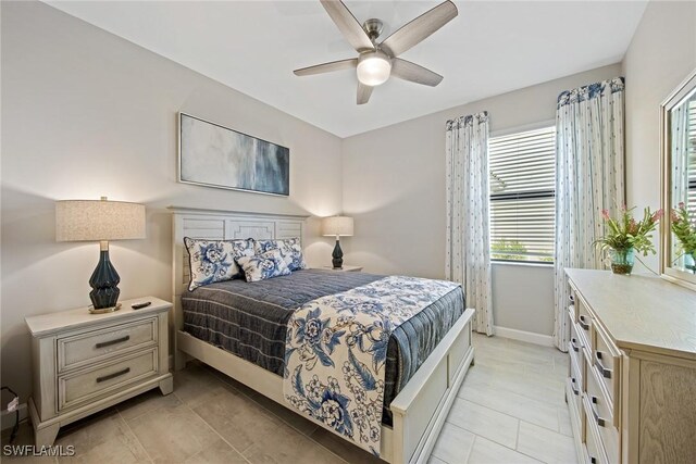 bedroom featuring light tile patterned floors, baseboards, and ceiling fan