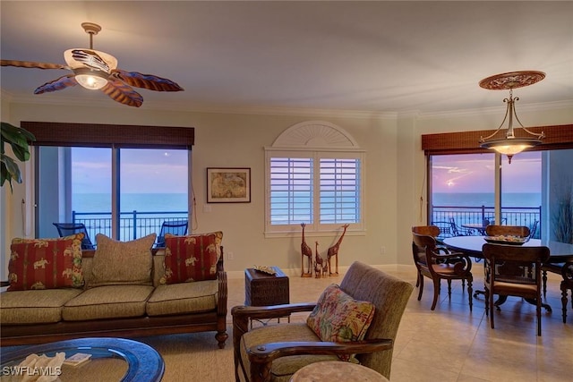 living room with a ceiling fan, a water view, crown molding, and light tile patterned floors