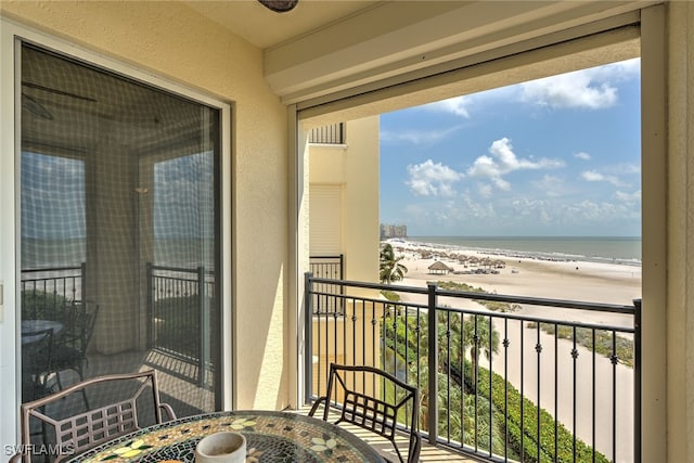 balcony featuring a beach view and a water view