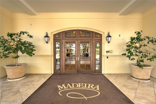 doorway to property featuring french doors and stucco siding