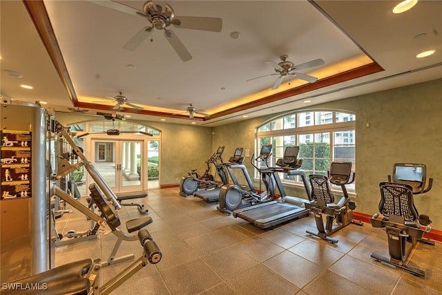 workout area featuring baseboards, a raised ceiling, and recessed lighting