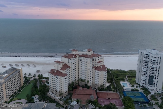 aerial view at dusk featuring a water view