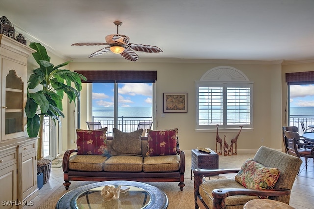 living room featuring ceiling fan, light tile patterned flooring, a water view, and ornamental molding