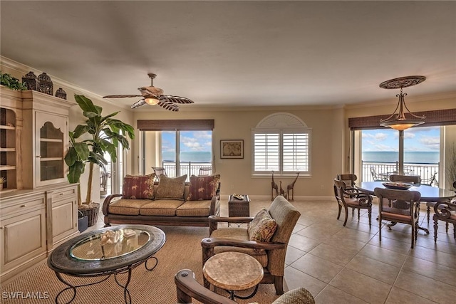 living room featuring light tile patterned floors, baseboards, ceiling fan, ornamental molding, and a water view