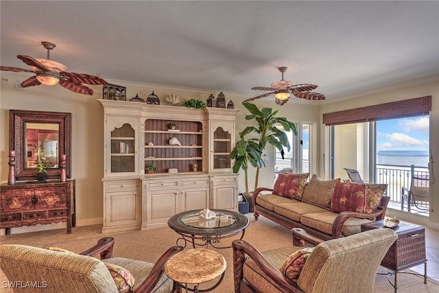 carpeted living room with ceiling fan, a water view, and ornamental molding