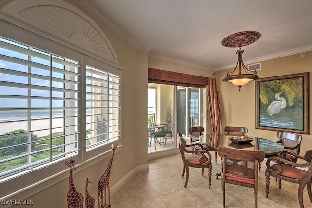 dining room with light tile patterned floors, baseboards, and crown molding