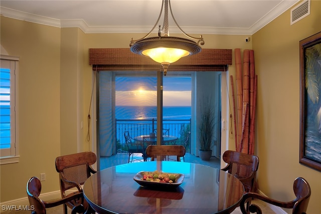 dining room with ornamental molding and a water view