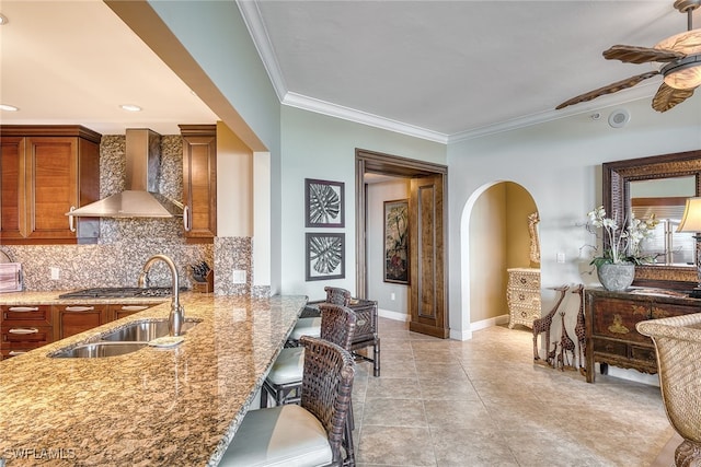 kitchen with tasteful backsplash, light tile patterned floors, ceiling fan, wall chimney range hood, and stainless steel gas stovetop