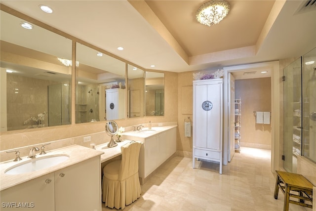 bathroom with a raised ceiling, vanity, tile patterned flooring, and an enclosed shower