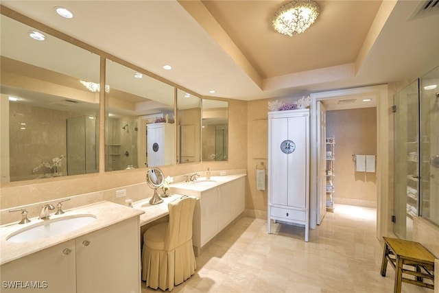 bathroom featuring two vanities, a tray ceiling, visible vents, and a sink