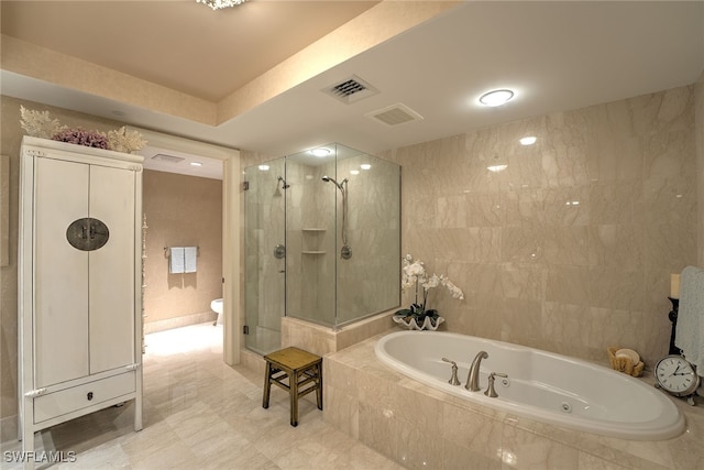 bathroom with plus walk in shower, toilet, tile patterned floors, and tile walls