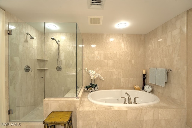 bathroom featuring tile walls and independent shower and bath