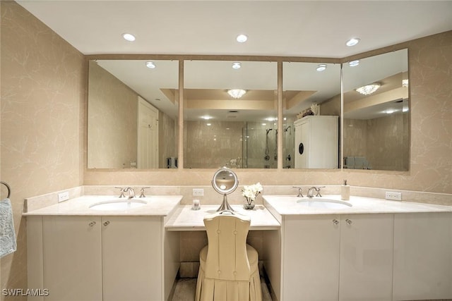 bathroom with a stall shower, two vanities, and a sink