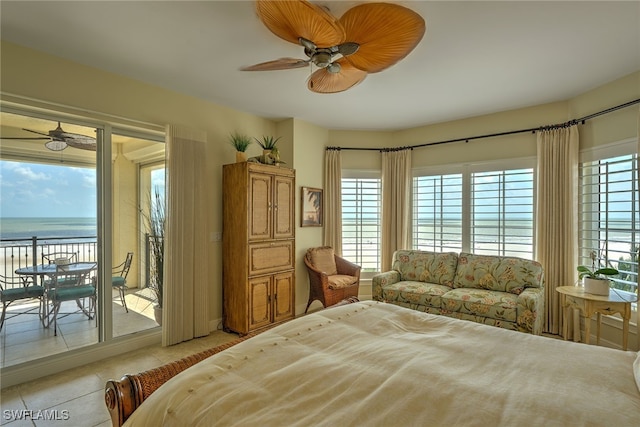 tiled bedroom featuring access to outside, a water view, ceiling fan, and multiple windows