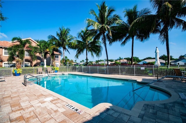 community pool with fence and a patio