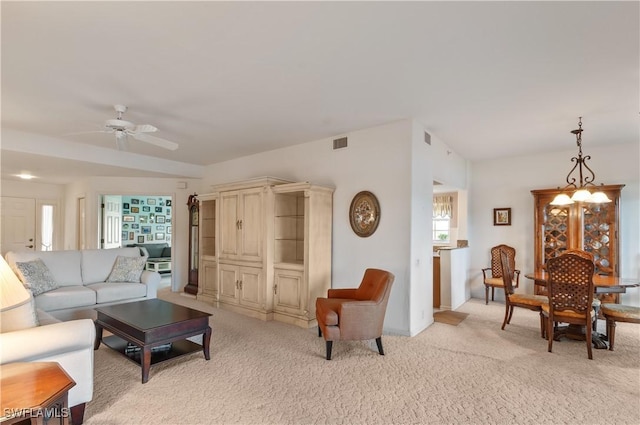 living area with ceiling fan, visible vents, and light colored carpet