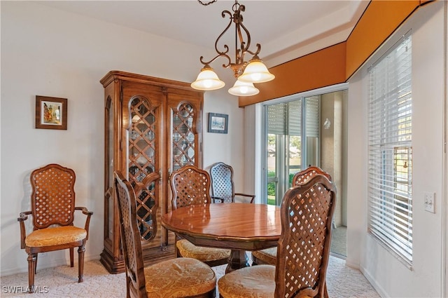 dining room with baseboards, a chandelier, and light colored carpet