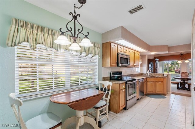 kitchen with decorative backsplash, sink, decorative light fixtures, kitchen peninsula, and stainless steel appliances