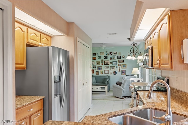 kitchen with ceiling fan, hanging light fixtures, sink, stainless steel fridge, and light tile patterned flooring