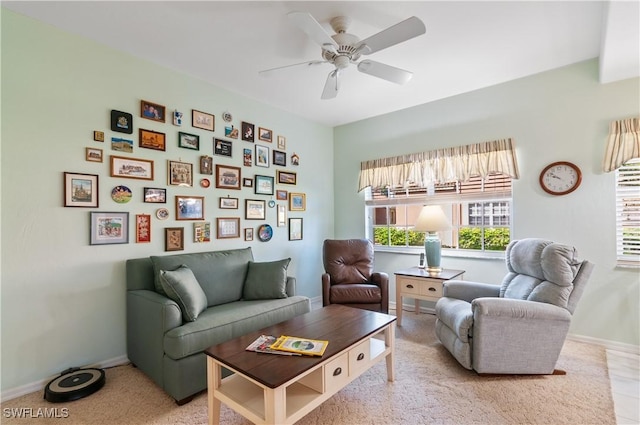 living area with baseboards and a ceiling fan