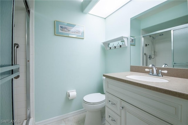 bathroom with baseboards, a tile shower, vanity, and toilet