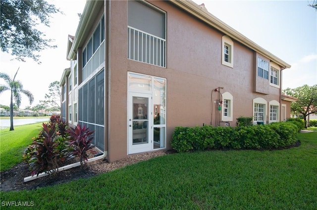 back of property featuring stucco siding and a yard