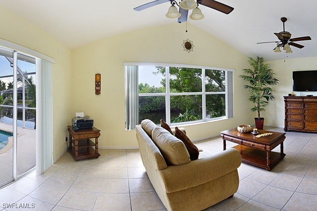 living room featuring light tile patterned floors, baseboards, vaulted ceiling, and a ceiling fan