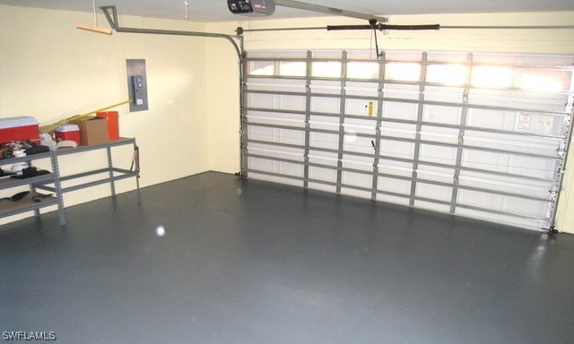 garage with electric panel and a garage door opener