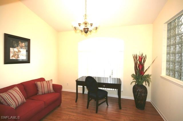 office with dark wood-style floors, baseboards, and an inviting chandelier