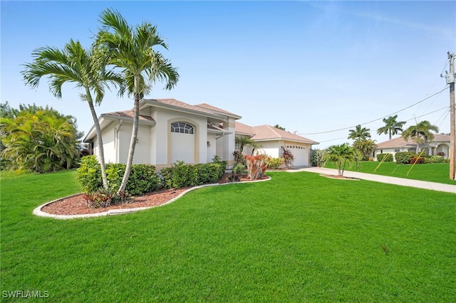 mediterranean / spanish-style house featuring an attached garage, a front lawn, concrete driveway, and stucco siding