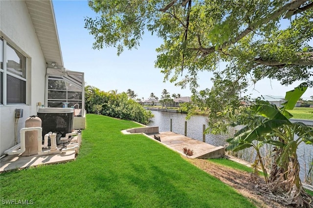 view of yard featuring a water view, glass enclosure, and a boat dock