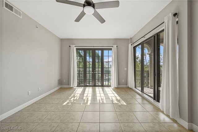 empty room with french doors, light tile patterned floors, and ceiling fan